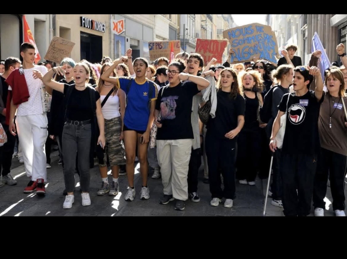Jeunes manifestants avançant dans une rue avec pancartes
